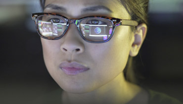 Female student with reflection of computer in her glasses