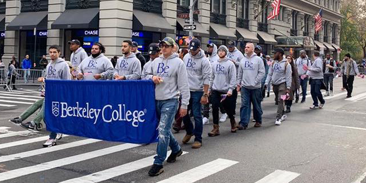 Berkeley College group walking with Berkeley College banner in gray Be Successful sweatshirts in NYC 