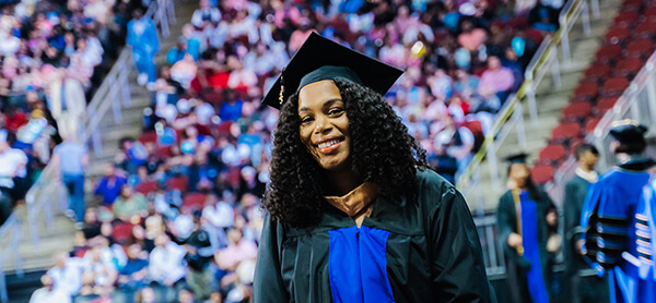 Female graduate smiling in cap and gown