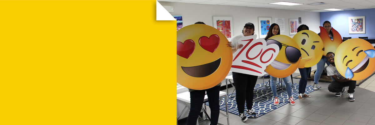 Students with emoji cut outs at New Student Orientation