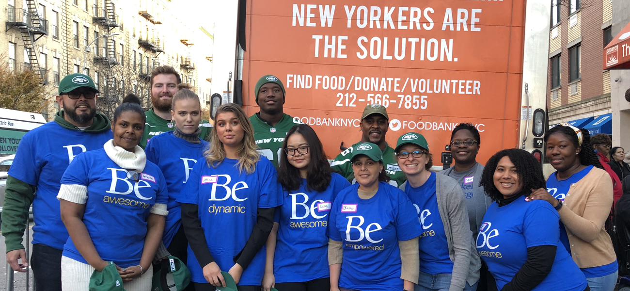 Group of Berkeley staff and students with players from the NY Jets in front of Food Bank of NY truck