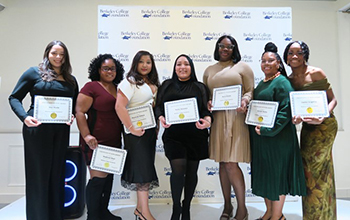 A group of people holding certificates smile and pose for the camera.