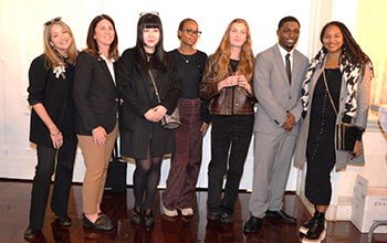 A group of diverse people poses and smiles at the camera.