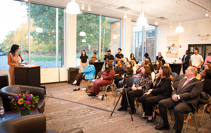 A woman speaks at the podium in front of a crowd