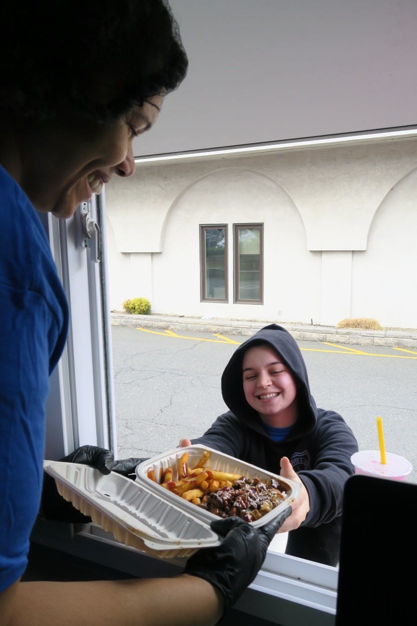 A student receives food from a chef at a food truck