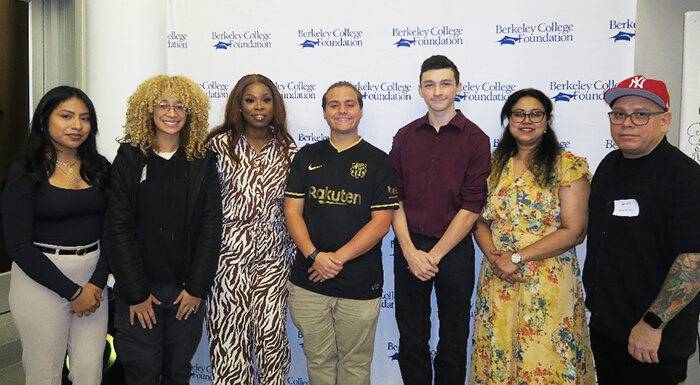 A diverse group of individuals stands united in front of a large banner