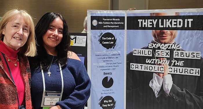  Two women pose next to a poster displaying the phrase they liked it