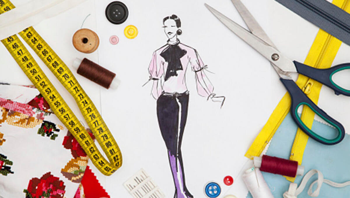 A fashion design sketch surrounded by a measuring tape, scissors, threads, buttons, and various sewing materials.