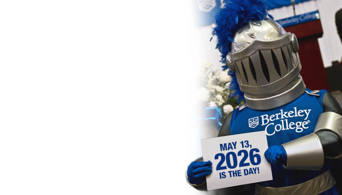 A mascot in knight attire holding a sign that says May 13, 2026 is the day with Berkeley College branding in the background