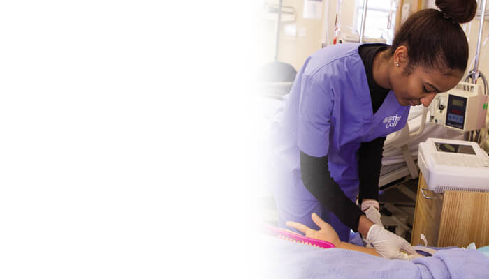 A nurse provides care to a patient in a hospital setting, demonstrating professionalism and compassion in her work