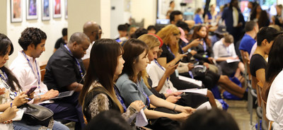 a diverse group of individuals seated in a straight line, engaged in conversation and sharing a moment together