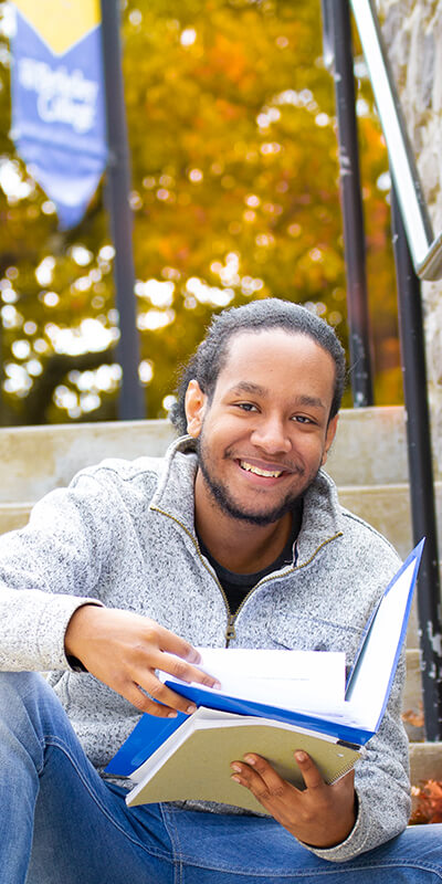 A man sitting on steps, absorbed in a book, enjoying a peaceful moment outdoors