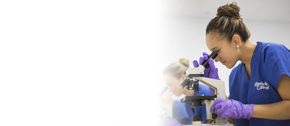 A female student focused on a microscope, analyzing samples in a laboratory environment