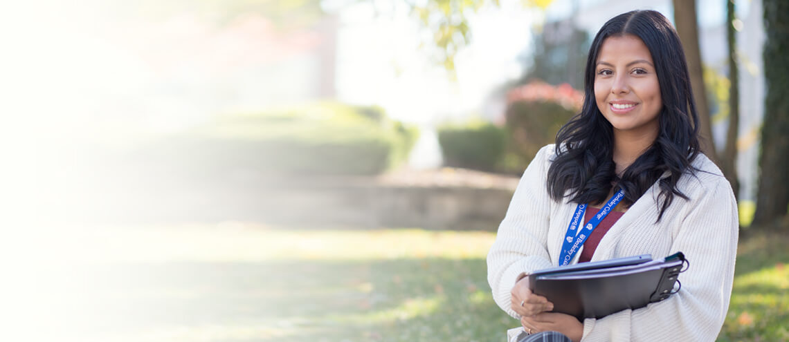 A young woman happily holds a folder, radiating positivity and confidence