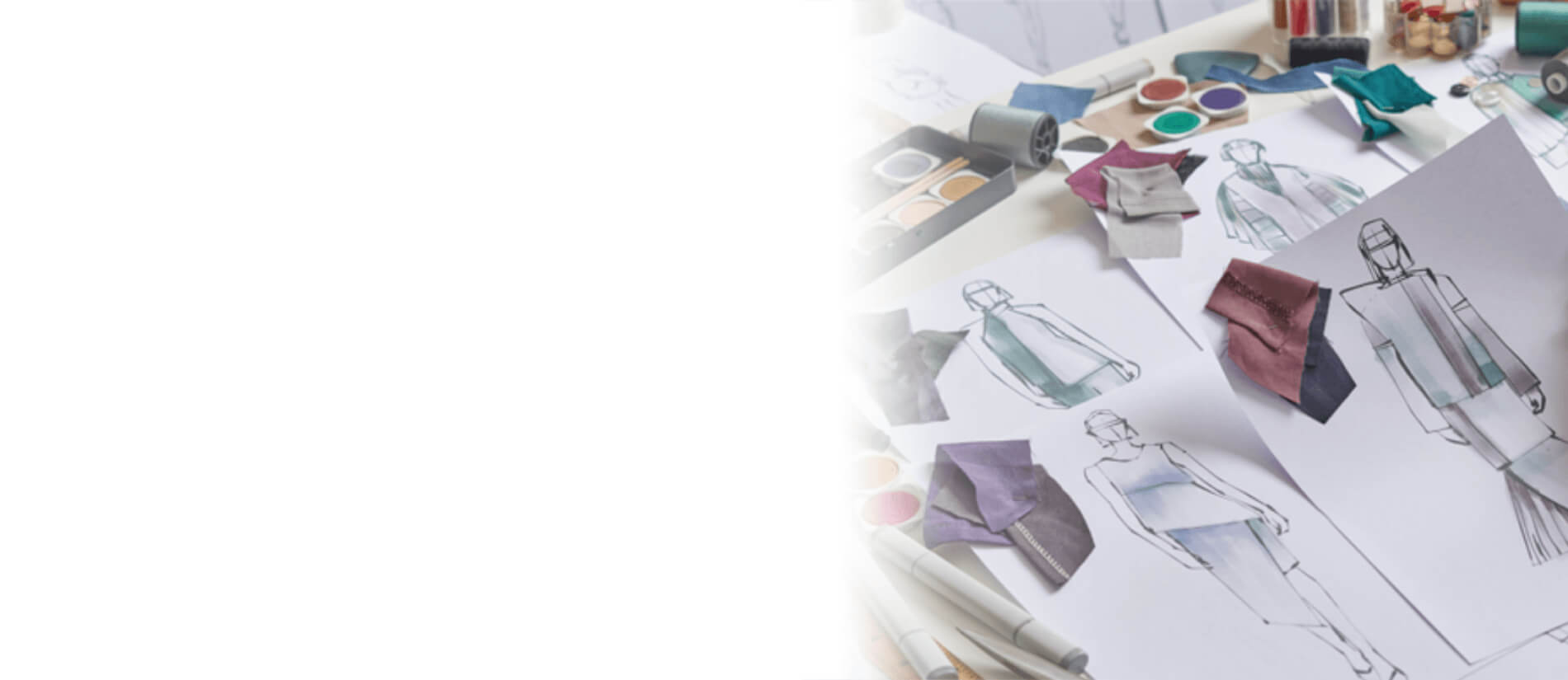 Fashion design workspace with clothing sketches and fabric swatches scattered on a table, fading into open white space; creative, airy mood.