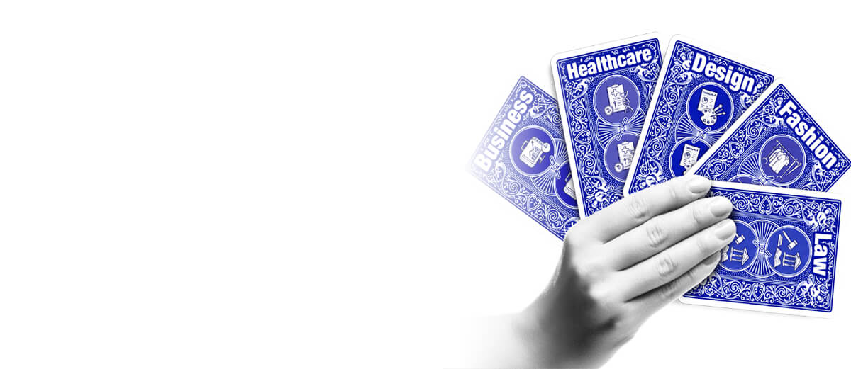 A hand displays four playing cards in various colors, showcasing a vibrant assortment of card designs