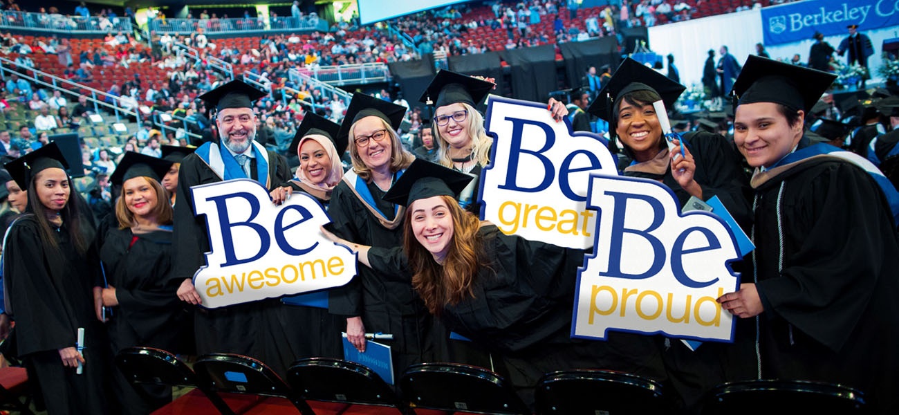 Faculty and Staff holding BE signs at Commencement