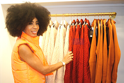 A woman wearing an orange vest, standing confidently