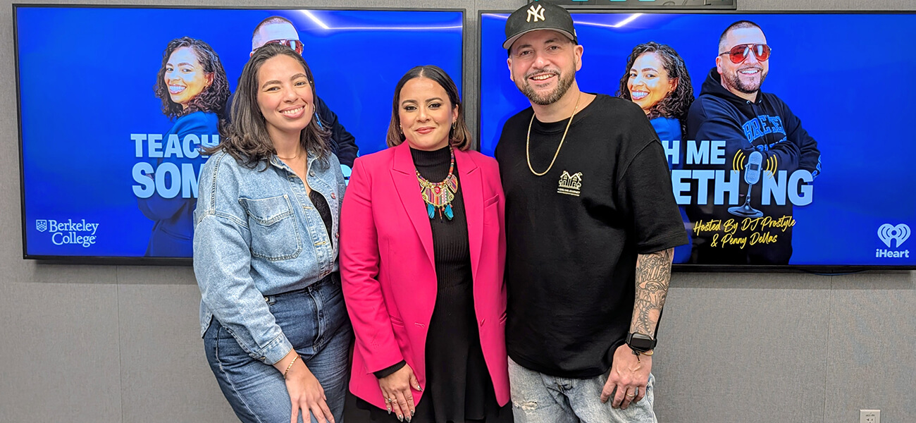 Three people standing in front of a blue Teach Me Something podcast screen with Berkeley College and iHeart logos