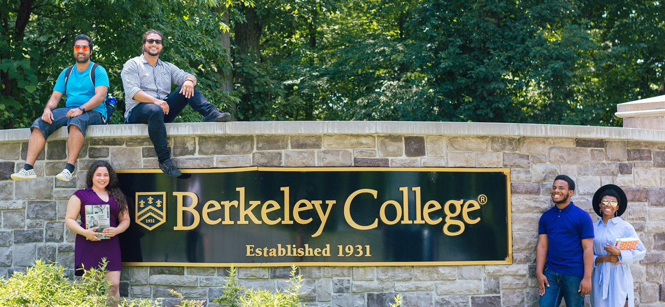 Students sitting on Berkeley College sign