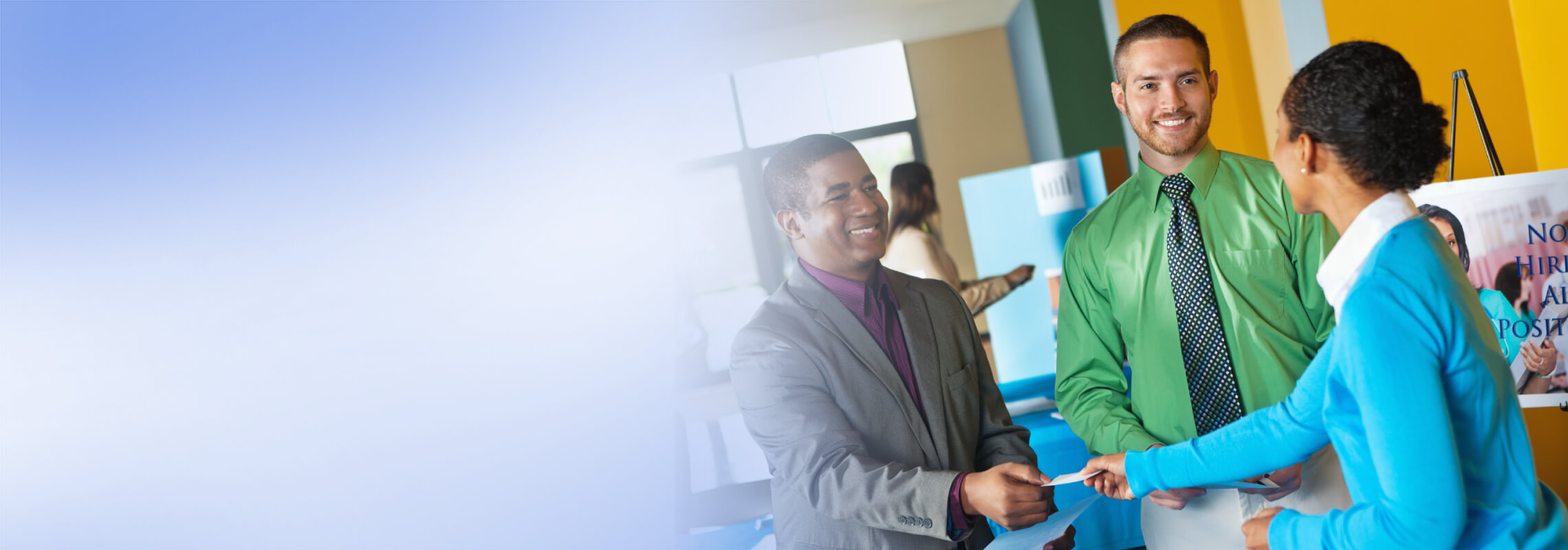 Image: Two men and a woman smiling and shaking hands in a brightly lit office, conveying a friendly and professional atmosphere.