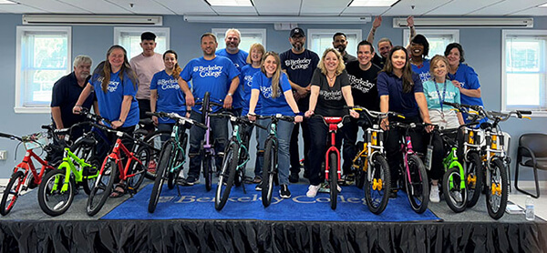 Group of people wearing blue shirts standing next to bicycles