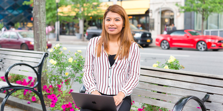 Female student on laptop outside