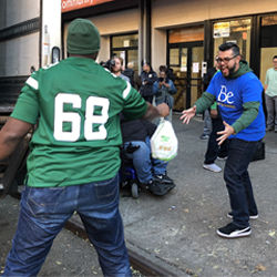 Jets player throwing turkey to Berkeley associate