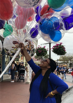 Imani Miller at DIsney holding balloons