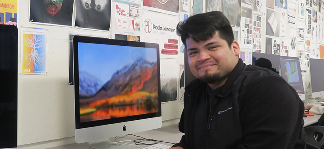 Male student sitting at computer in design lab