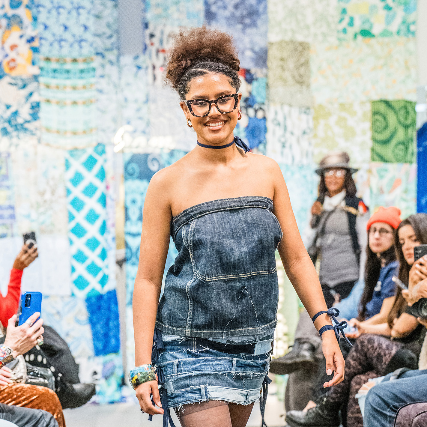 A woman in a dress walks down the runway