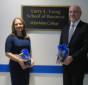 two individuals posing in front of a sign reading Larry L Luing School of Business