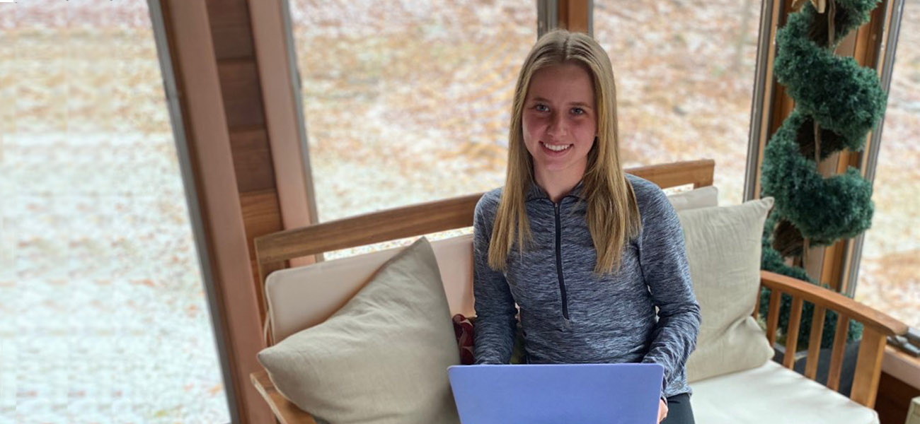 Female student working on laptop at home