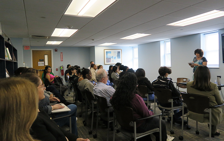 A woman gives a speech to a diverse audience.