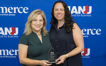 Two women smiling and holding a trophy