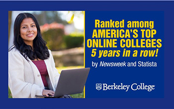 A woman smiles and works on a laptop.