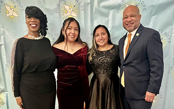 Four people stand and pose for a photo.