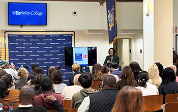 a woman speaks at a podium in front of an audience