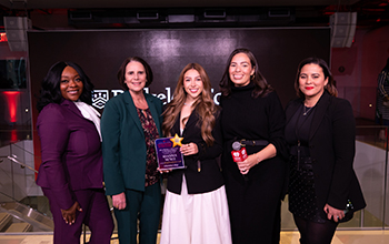 women smile with an award and microphone