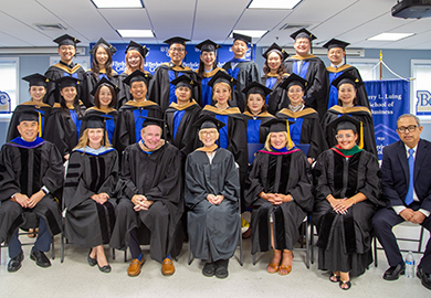graduates pose in gowns