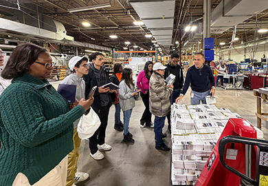 students listen to a speaker and look at blueprints
