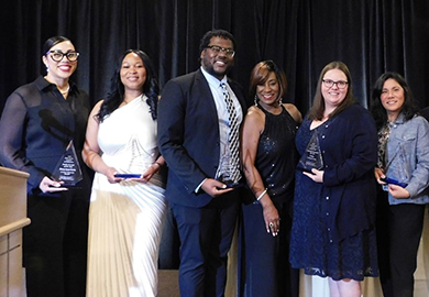 A group of adults pose with an award