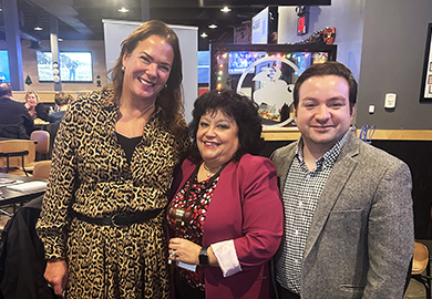 two women and a man hold a gavel