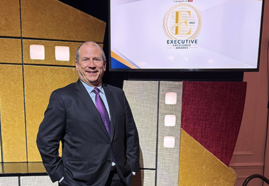 a man in a suit stands near a tv