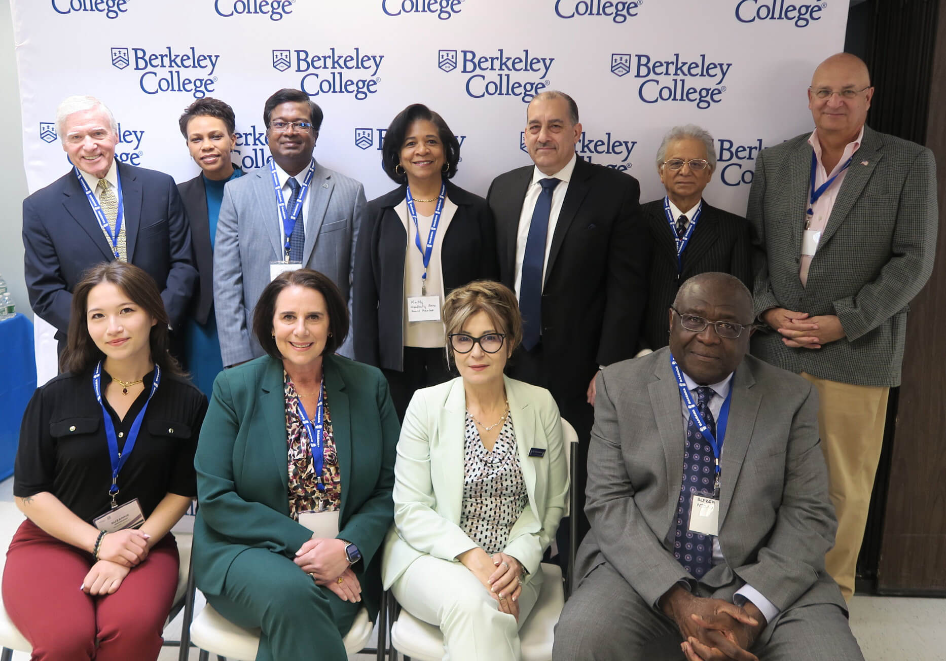 Group portrait of 11 professionals wearing name badges, posing in front of a Berkeley College branded backdrop.