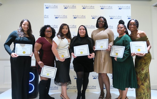 A group of students with certificates smile and pose for the camera