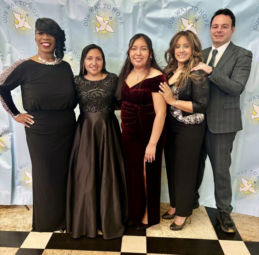 Five people stand and pose for a photo.