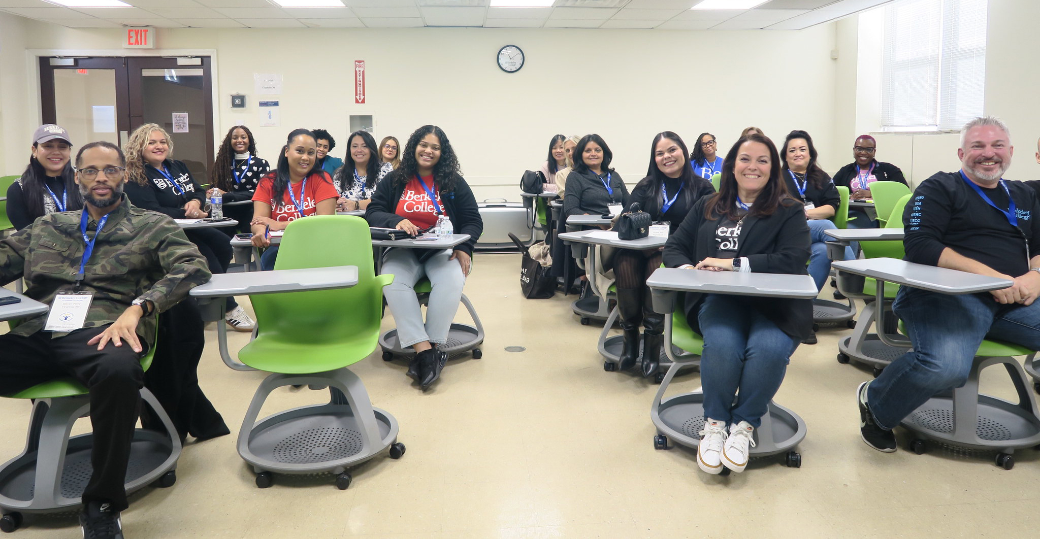 A group of faculty and staff sit in desks