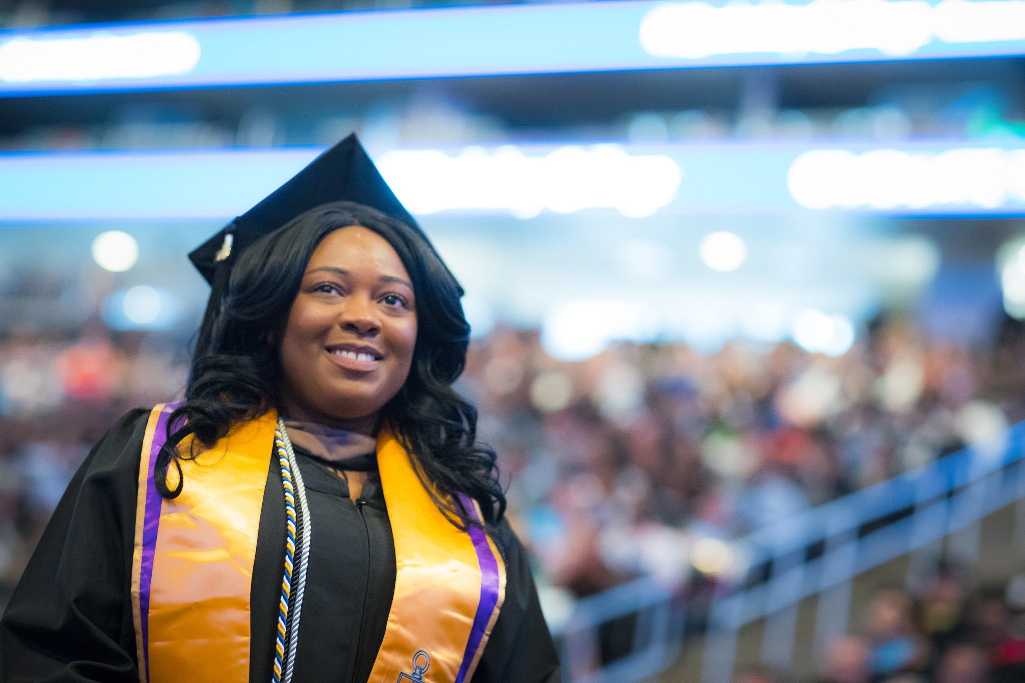 a woman looks up in a graduation cap and gown