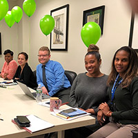 Associates with green balloons